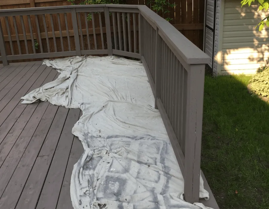 Drop cloths protecting the decking while staining